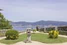 Área ajardinada con escultura y vistas al mar desde el Monte O Castro