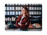 Mujer de pie en un ambiente de cafetería o espacio de trabajo moderno