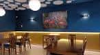 Comedor de un restaurante con paredes azules, iluminación moderna y mesas de madera en Vigo
