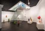 Espacio interior de la galería con escalera de cristal y esculturas