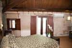 Amplia habitación de hotel con cama grande y vigas de madera en el techo