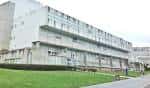 Fachada lateral de un edificio universitario con césped