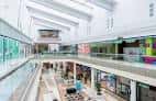 Vista interior de los pasillos y tiendas en varios niveles del centro comercial