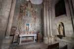 Interior de una capilla de la Catedral de Santiago con retablo y paredes de piedra