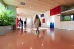 Pasillo interior moderno de la Facultad de Biología con personas