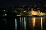 Panorámica nocturna de la Antigua ETEA desde la ría con reflejos en el agua