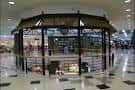 Estructura circular central con techo de paja en el área común del centro comercial
