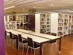 Sala de lectura de la biblioteca con mesas y estanterías