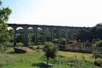 Viaducto de A Chanca en Lugo, enmarcado por la vegetación y el paisaje rural.
