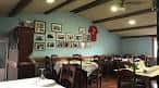 Comedor tradicional del Bar Nisio con vigas de madera y cuadros en la pared
