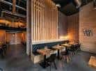 Interior de restaurante Sibuya con paneles de madera y asientos tipo cabina