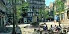 Ambiente diurno en la Plaza de la Princesa con terrazas y transeúntes