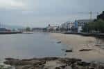 Playa de Bouzas en un día nublado, mostrando la costa y el pueblo