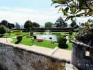 Jardín formal con fuente y setos bien cuidados en la fortaleza