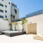 Terraza exterior del hotel con zona de descanso y vegetación