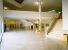 Amplio vestíbulo interior de la Facultad con escaleras y luz natural