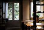Comedor o sala común interior con mesas y vistas al jardín