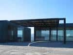 Entrada exterior de un centro cultural moderno con pérgola