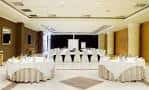 Sala de eventos configurada con mesas redondas y área de presentación