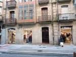 Edificio con varias tiendas en la calle Benito Corbal, incluyendo Sfera.