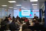 Sala de conferencias con audiencia y pantalla de presentación