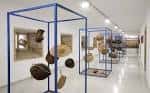 Galería interior del museo con exposición de objetos culturales en estructuras modernas.