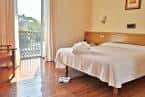 Habitación de hotel con cama doble y acceso a balcón