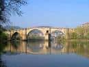 Vista del Puente Romano sobre el río Miño con reflejos