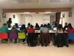 Sala de formación o taller con participantes en mesas