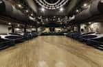 Interior de la sala de eventos con pista de baile y mesas vacías