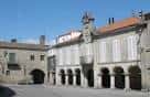 Edificio de piedra con soportales y arcos en la Plaza Méndez Núñez