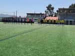 Equipo de fútbol alineado en el campo de césped artificial