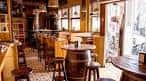 Interior de la Taberna Zentola con mesas de madera y barriles