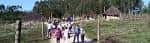 Visitantes explorando el sendero del parque con las cabañas al fondo