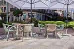 Zona de terraza con mesas, sillas y sombrillas abiertas
