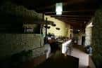 Interior de un bar o restaurante rústico con paredes de piedra y vigas de madera