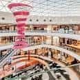 Interior del Centro Comercial Cuatro Caminos con decoración espiral y múltiples niveles