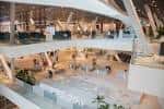 Amplia vista interior del atrio central del centro comercial con escaleras y espacios abiertos