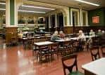 Sala interior con mesas y sillas, ideal para tertulias o reuniones