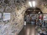 Interior de la Oficina de Turismo de Betanzos con paredes de piedra y expositores