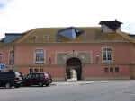 Fachada de un edificio histórico de la Universidade da Coruña con arco de entrada
