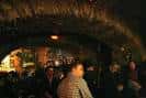 Ambiente interior del pub Modus Vivendi con clientes y decoración rústica