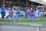 Jugadores en el campo de fútbol con gradas en la Ciudad Deportiva de Abegondo