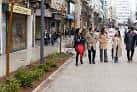 Peatones en la Rúa San Andrés con comercios y arbolado