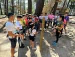 Grupo de personas recibiendo instrucciones en el Parque de Aventuras de Beade, preparándose para una actividad