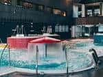 Zona de piscina termal con chorros de agua y elementos de hidromasaje
