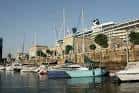 Embarcaciones en la Dársena de A Laxe con un gran buque o edificio en el muelle