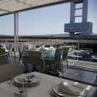 Comedor interior moderno con mesas preparadas y vistas al puerto