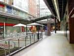 Pasillo interior del centro comercial Área Central con zonas de descanso