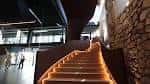Escalera interior moderna e iluminada con pared de piedra